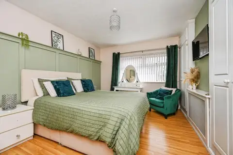 Main double bedroom with fitted storage and green feature wall